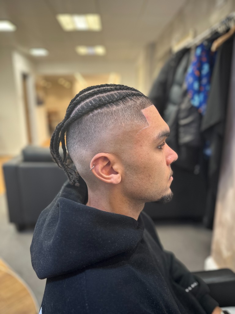 Profile view of cornrows with a high fade